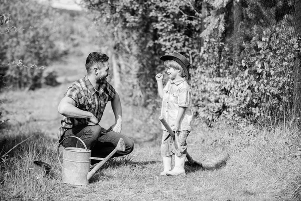 Uma pequena pausa. Feliz Dia da Terra. Viveiro de árvores genealógicas. Pai e filho de chapéu de cowboy no rancho. regar lata, panela e pá. Equipamento de jardim. Eco fazenda. menino pequeno criança ajuda pai na agricultura — Fotografia de Stock