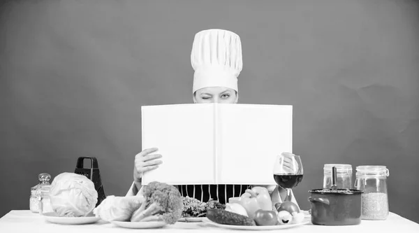 Ze is een super kok. Lady kok op zoek naar het recept in kookboek koken. Mooie vrouw lezen kookboek in keuken. Schattig cook huishoudster op de keukentafel, kopie ruimte — Stockfoto