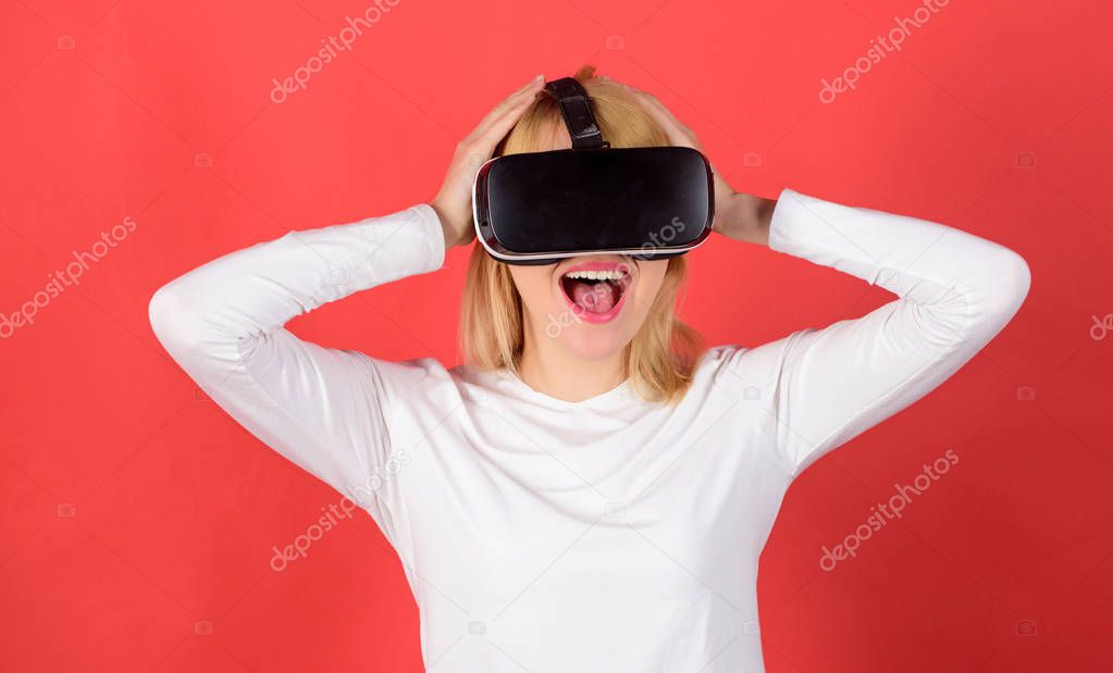 Amazed young woman touching the air during the VR experience. Woman wearing virtual reality goggles. Funny young woman with VR. Futuristic VR.