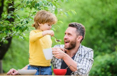 Bebeği besliyor. Çocuklar için menü. Aile ev yapımı yemeklerin tadını çıkarır. Baba oğul yemek yer ve eğlenir. Yemek alışkanlıkları. Babası yla birlikte yiyecek doğa geçmişi yiyen küçük bir çocuk. Yaz kahvaltısı. Sağlıklı gıda kavramı