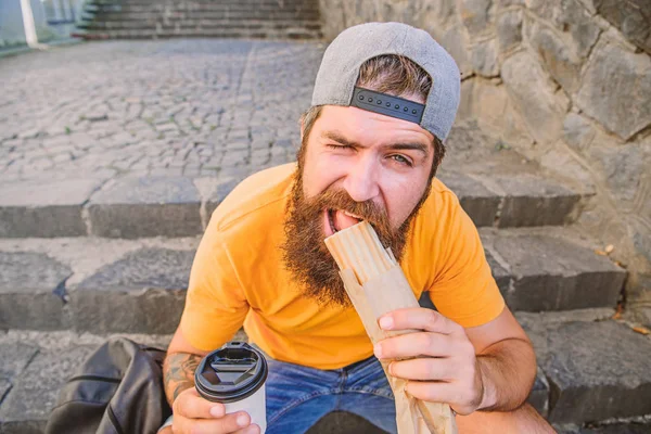 Melhores ingredientes, melhor cozinha. Homem barbudo comendo comida rápida insalubre. Caucasiano viajante cara desfrutando de cozinha de rua. Hipster ter cozinha tradicional cachorro-quente durante o descanso — Fotografia de Stock