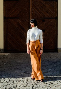 Kadınlık ve kadınsı rakam vurgulamak. Kadın moda kıyafeti. Kız makyaj yüz moda trendi eşleşen giysiler. Stilist moda uzmanı. Yüksek belli pantolonlar podyuma dönmeye devam ediyor. Moda kız