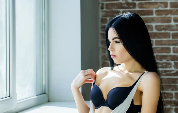 Sexual costume for pleasure. Passionate mysterious lover. Enjoying morning sunlight. Sensual girl sexy breasts relaxing near windowsill. Attractive female sexy lingerie at home. Stunning sexuality — Stock Photo, Image