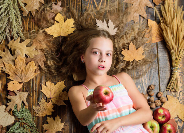 Не хочешь попробовать? Маленькая девочка дает яблоко. Симпатичный ребенок с спелыми осенними культурами. Маленькая девочка любит вкус яблочных фруктов. Витаминные продукты для здорового роста. Органическое и натуральное питание для здоровья детей
