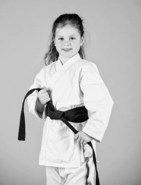 Aktivite ve spor. Güçlü ve kendine güvenen bir çocuk. Kemerli beyaz kimonolu küçük çocuk. Karate dövüşçüsü savaşmaya hazır. Karate spor konsepti. Kendini savunma becerileri. Karate güven hissi verir
