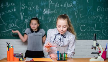 İşe odaklanmak. Kimya araştırması. Okul laboratuarındaki küçük kızlar. Örgün okul eğitimi. Biyoloji okulu dersi. Küçük bilim adamları mikroskopla çalışır. laboratuvarda bilim deneyleri