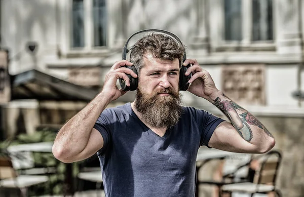 Hombre barbudo auriculares hipster escuchando música. Hipster disfrutar de una excelente canción de sonido en los auriculares. Caminando con música. La música late por el estado de ánimo enérgico. Ritmo para caminar. Excelente lista de reproducción de música — Foto de Stock