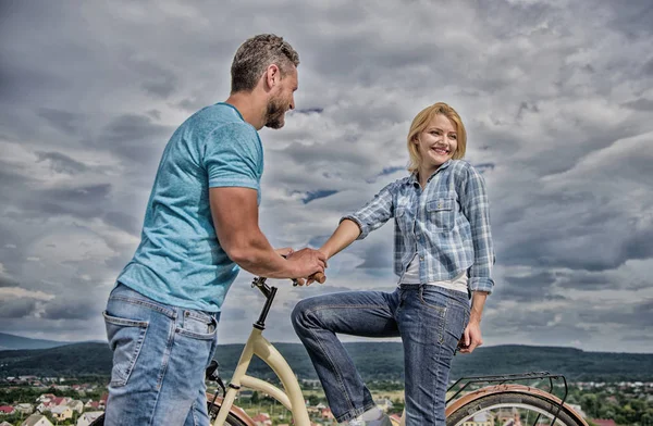 Rolling romance or bike date. Man with beard and shy blonde girl on first date. Woman feels shy in company with attractive macho. Couple just meet to hang out together. asual acquaintance concept
