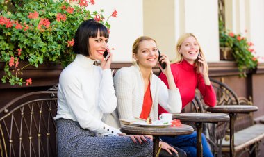 Konuşmaya kafayı takmış. Dijital cihazları kullanmak. Grup kadın kafe terasında. Arkadaşlık toplantısı. Mobil bağımlısı. Mobil konuşma. Cep telefonu olan kızlar. Arkadaşlar kahve dükkanında oturup konuşmanın tadını çıkarırlar.