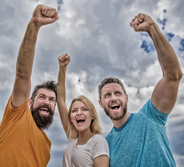 La mujer y los hombres se ven seguros de éxito fondo del cielo. Comportamientos del equipo cohesivo. Celebra el éxito. Sí que podemos. Formas de construir un equipo cohesivo. Trío de pie feliz con confianza con los puños levantados — Foto de Stock