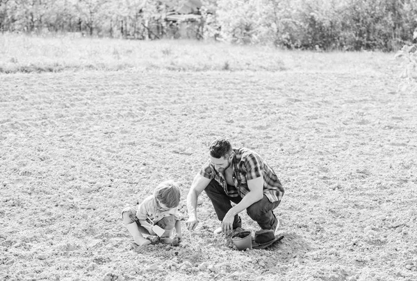 Petit garçon enfant aider père dans l'agriculture. nouvelle vie. sols et engrais. père et fils plantant des fleurs dans le sol. heureux jour de la terre. Arbre généalogique. riche sol naturel. Eco ferme. Jour de la Terre. Réussir — Photo