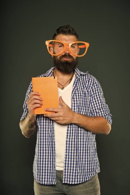İnek yeni cool olduğunu. Kitap nerd çalışma. Kitap nerd süslü gözlük takıyorum. Üniversite erkek öğrenci ders notları ile. Adam ders kitabı ile parti bardaklarda sakallı