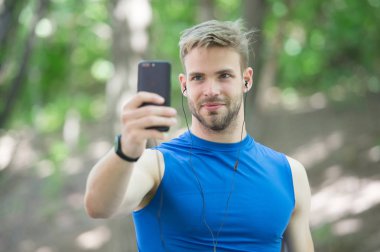 Telefondaki spor uygulaması. Dijital spor. Akıllı saat. Spor giyim sektöründeki atletik adam selfie çekiyor. Açık hava antrenmanı. Fitness uygulaması. Ui ux kavramı. Modern sporda bir alet. İz sürücüdeki kaslı adam. bağlantı araması