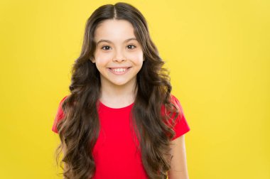 Moda güzeli. hippi çocuk. Uzun kıvırcık saçlı mutlu kız. çocukluk mutluluğu. Küçük kız gülüşü. Kuaför salonu. Cilt bakımı ve doğal saç. Saçları gür ve bakımlı. Şampuan ve saç kremi.