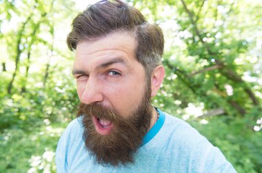 Bıyık bana yaptırdı. Sakallı adam şık bıyık şekli ile göz kırpıyor. Traşsız yüzünde dokulu bıyıklı saçları olan acımasız hipster. Uzun sakal ve bıyık lı beyaz adam