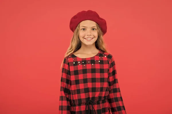 Beret style inspiration. How to wear beret like fashion girl. Fashionable beret accessory for female. Kid little cute girl with long hair posing in hat red background. How to wear french beret