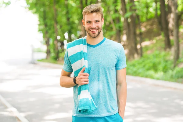 Sabah eğitimi için motive. Havlu doğa arka plan ile Adam atlet. Atletik adam rahatlatıcı mola. Atlet yorucu egzersizler sırasında mola alır. Koşucu egzersiz açık. Yakışıklı atlet