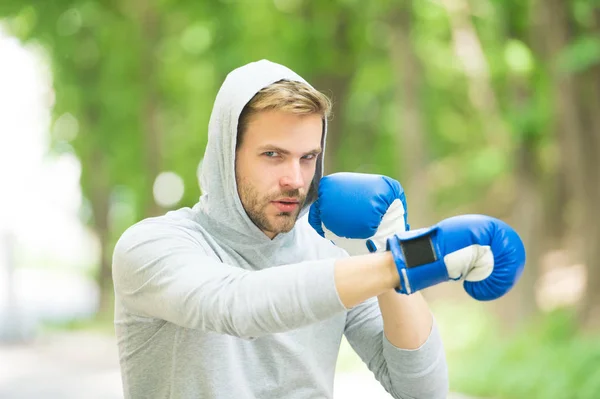 Be strong. man in boxing gloves punching. Sport and sportswear fashion. boxer man in hood. ready to fight. knockout and energy. Sport success. Boxing school. training with coach. healthy fitness — Stock Photo, Image