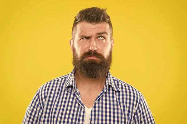 Need to think. Man serious face raising eyebrow not confident. Have some doubts. Hipster bearded face not sure in something. Doubtful bearded man on yellow background close up. Doubtful expression