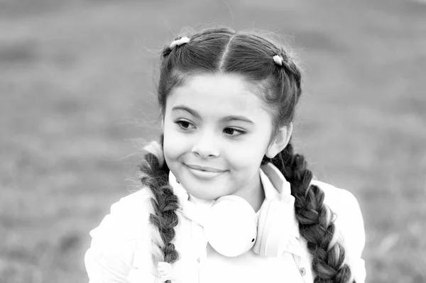 Criança feliz emocional saudável relaxando ao ar livre. Fica feliz. Menina fones de ouvido modernos desfrutar relaxar. Vê o lado positivo. Segredos para criar uma criança feliz. Menina bonito criança verde grama fundo — Fotografia de Stock