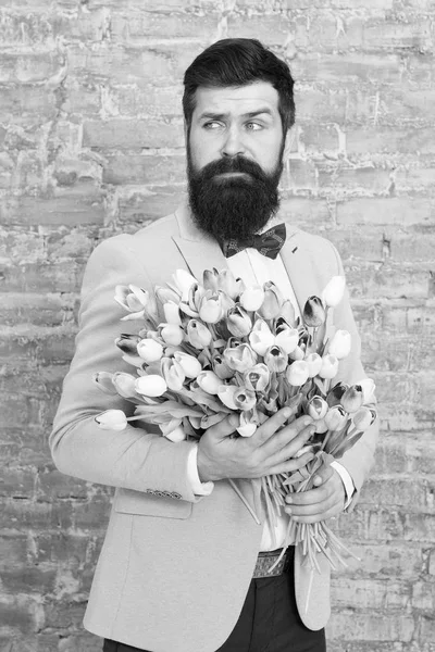 Flower for March 8. Bearded man with tulip flower bouquet. Love date. international holiday. Spring gift flowers. Bearded man hipster with flowers. Womens day. Impossible scent. Spring allergy