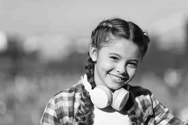 For enjoying sound of music. Adorable music fan with wireless headset on neck. Little child using technology for listening music. Small girl with stereo headphones. Music education