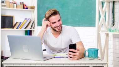 Erkek okul öğretmeni iletişim için modern teknolojiyi kullanır. Web geliştirme ve çevrimiçi iletişim. Lise üniversitesi. Öğrenci akıllı telefon iletişimini kullanır. Gençlik modern bilgi gerektirir