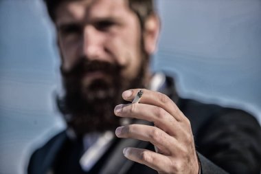 Sigarayı bıraktım. Bulanık usinessman gökyüzüne karşı. Gelecekteki başarısı. Erkek resmi moda. Sakallı adam sigara içiyorum. duman. Bıyıklı acımasız beyaz hippi. Olgun hipster sakallı