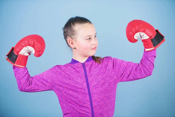 Happy child sportsman in boxing gloves. success. sportswear fashion. punching knockout. Childhood activity. Fitness diet. energy health. workout of small girl boxer. Towards the healthier lifestyle