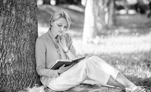 Zelfverbetering boek. Haar kennis van de verbetering van de zakelijke dame zoeken minuut om boek te lezen. Meisje leunen op boom terwijl ontspannen in park sit gras. Zelf verbetering en onderwijs concept. Vrouwelijke zelfverbetering — Stockfoto