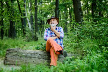 düşünceli adam. derin ahşap yürüyüş. orman sahibi. yaz veya bahar pikniği. kıdemli adam çiftçi ormanda dinlenmek. şapkasakallı olgun adam. çiftçi ahşap üzerinde oturup. mutlu ormancı. insan ve doğa