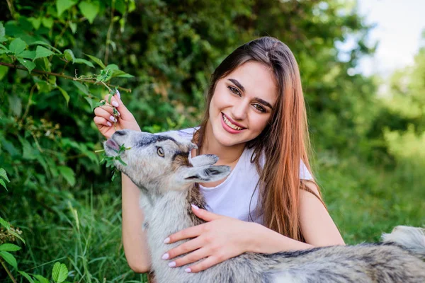 Veterinární lékař pečovat o kozí maso. žena veterinářka koza. zemědělský a zemědělský koncept. Zvířata jsou naši přátelé. šťastná dívka miluje kozu. vesnický víkend. letní den. Milovat a ochraňovat zvířata. Zoologická zahrada — Stock fotografie