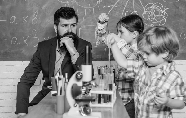 Desenvolvimento precoce das crianças. de volta à escola. instrumento óptico de microscópio em sala de aula de ciências. crianças felizes professor. aprender a usar microscópio na lição da escola. Professor curioso trabalhando na escola — Fotografia de Stock