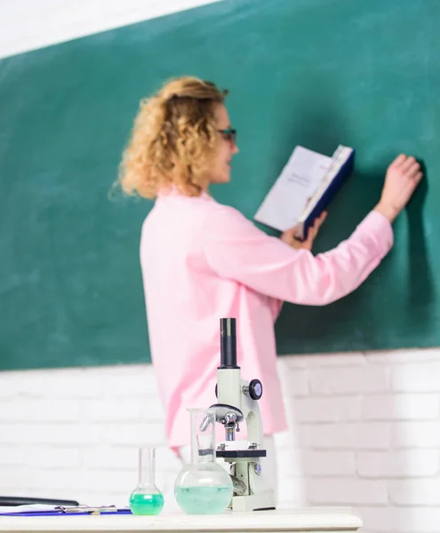 Student writing chalkboard defocused. Biology concept. Biology laboratory. Microbiology and bioengineering. Microscope ant tubes with chemical liquids on table school biology teacher selective focus — Stock Photo, Image