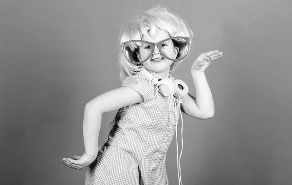A legmenőbb modern zenét. Kis modern lány fél stílusban visel Bluetooth fejhallgatót. A kisgyerek minden nap táncolhat a modern zenére. A modern technológia használata a kedvtelési célú — Stock Fotó