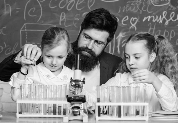 Man bearded teacher work with microscope and test tubes in biology classroom. How to interest children study. Explaining biology to children. Fascinating biology lesson. School teacher of biology