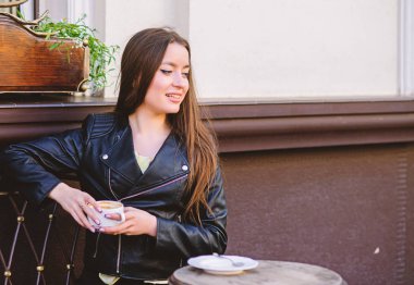 Kahvaltı zamanı. kız kafede dinlenmek. İş yemeği. Yaz. Sadece rahatlıyor. Kafede toplantı. Mutlu kız. deri ceketli şık kadın kahve içmek. sabah kahvesi. Randevuyu bekliyorum. Günaydın