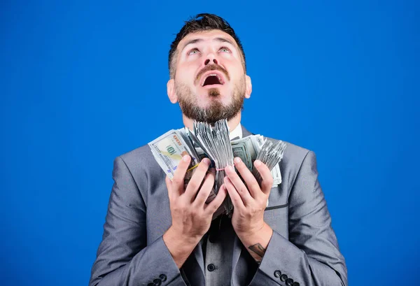 Muž formální oblek má mnoho dolarových bankovek modrý pozadí. Obchodník dostal peníze. Vezmi si moje peníze. Získat skutečné peníze. Pojem bohatost a blahobyt. Obchod s hotovostí. Snadný hotovostní úvěr — Stock fotografie