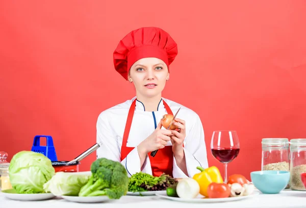 Vrouw in Cook hoed. Restaurant menu. Dieet. biologisch eten en vegetarisch. Huisvrouw. professionele chef-kok op rode achtergrond. Gelukkige vrouw koken gezond eten door recept. Vegetarische keuken rijke vitaminen — Stockfoto