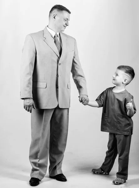 togetherness. trust and values. fathers day. family day. father and son in business suit. male fashion. happy child with father. business partner. small boy doctor with dad businessman. childhood