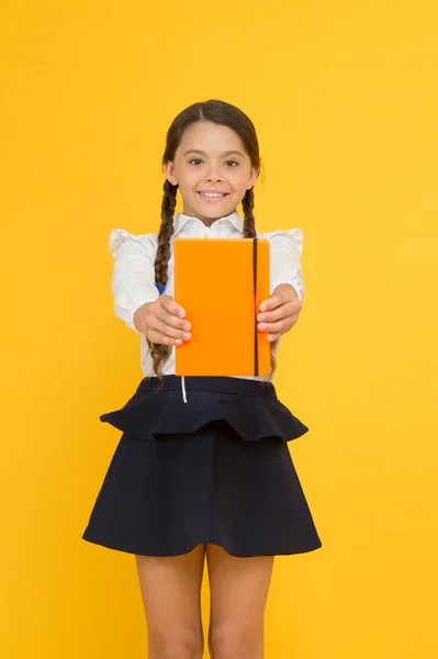 Lektüre zum Vergnügen. Nettes kleines Schulkind mit Lesebuch auf gelbem Hintergrund. entzückendes kleines Mädchen lernt Lesen in der Grundschule. Lesen entwickelt den Geist, Kopierraum — Stockfoto