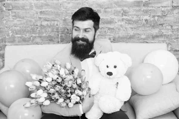 More than words. Womens day. Flower bouquet for March 8. Love bouquet. international holiday. happy bearded man with tulip bouquet, bear. Spring gift. Bearded man hipster with flower bouquet