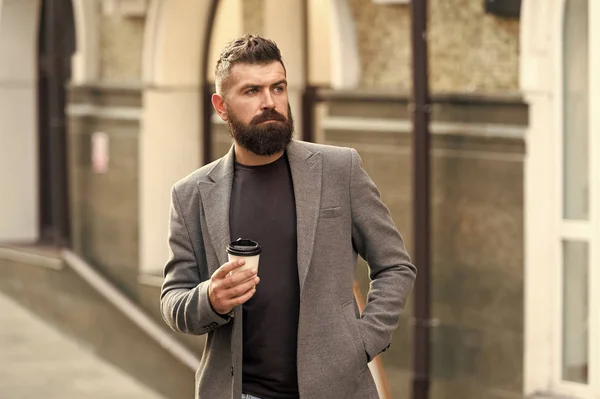 Coffee time. Businessman in hipster style holding takeaway coffee. Hipster with disposable paper cup walking in city. Bearded man enjoying morning coffee. Drinking his cup first thing in the morning — Stock Photo, Image
