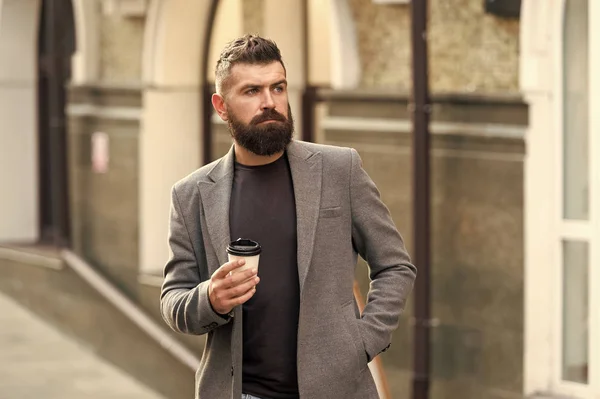 Koffie tijd. Zakenman in hipster stijl afhaalmaaltijden koffie houden. Hipster met wegwerp papieren kopje wandelen in de stad. Bebaarde man genieten van koffie in de ochtend. Drinken zijn kopje eerste ding in de ochtend — Stockfoto