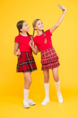 aile bağları. kardeşlik ve dostluk. mutlu bilgi günü. çocukluk mutluluğu. eğitim kavramı. Okula geri dön. sosyal ağ. Üniformalı kızlar. küçük kızlar telefonda selfie yapmak. Eğleniyor