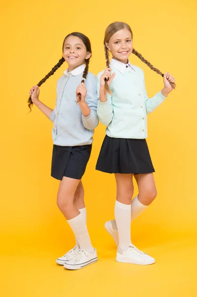 Listo para estudiar. concepto de educación. de vuelta a la escuela. niñas inteligentes sobre fondo amarillo. chicas felices en uniforme escolar. Moda infantil. Amistad y hermandad. Día del conocimiento. felicidad infantil —  Fotos de Stock