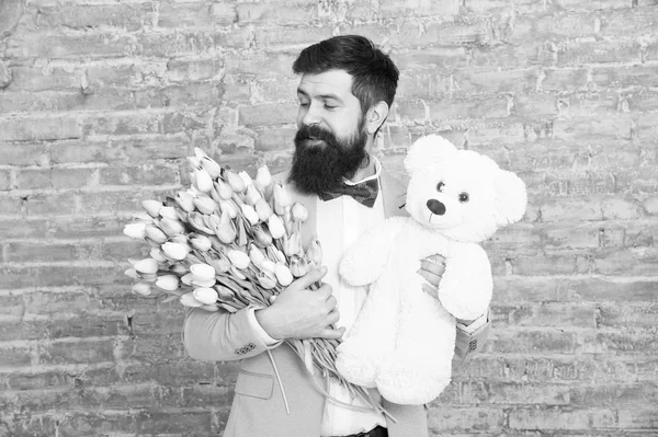 Thank you. Spring gift. Bearded man hipster with spring flowers. Bearded man with tulip bouquet and bear. Womens day. March 8. Love date. international spring holiday. spring holiday celebration