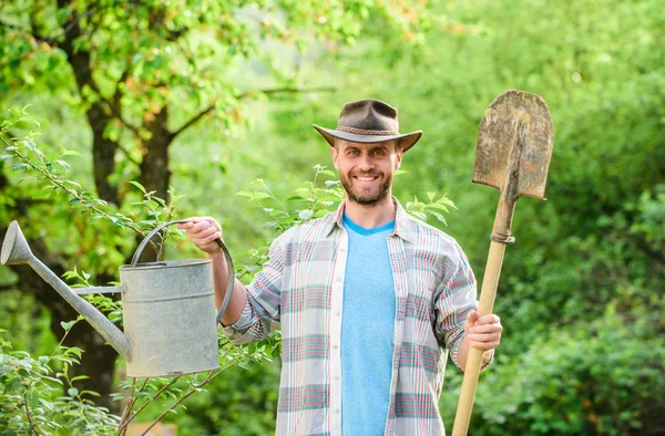 happy earth day. Eco living. Eco farm. Harvest. sexy farmer hold shovel and watering can. farming and agriculture. Garden equipment. muscular ranch man in cowboy hat. Taking good care of plants