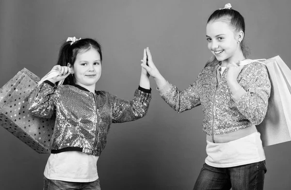 Porque a imagem é tudo. Meninas irmãs amigos com sacos de compras fundo violeta. Compras e compras. Sexta-feira negra. Venda e desconto. Dia das compras. Pacotes de crianças. Crianças moda — Fotografia de Stock