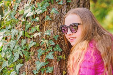 Bahar tatili. Yeşil çevre. parkta mutlu çocuk. Yaz. Doğal güzellik. Çocukluk mutluluğu. küçük kız parkta boş zaman geçirmek. sarmaşık yaprakları ile ağaç üzerinde tırmanma bitki. Çok güzelsin